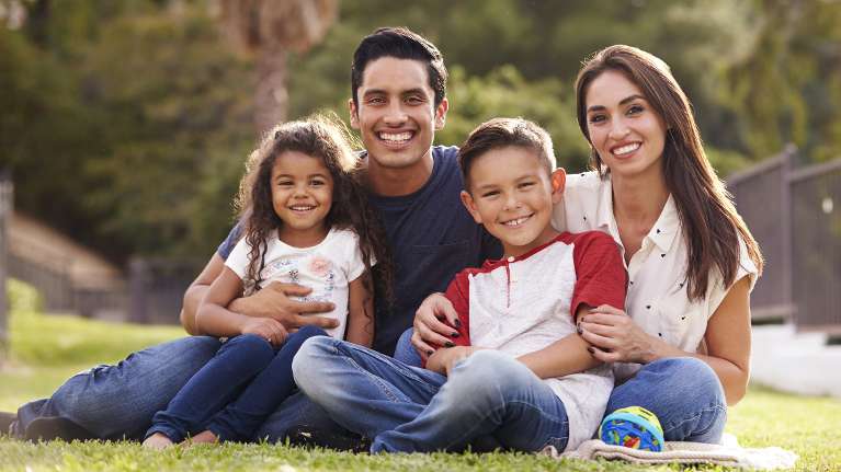 mother, father, son, and daughter smiling in a Phoenix park
