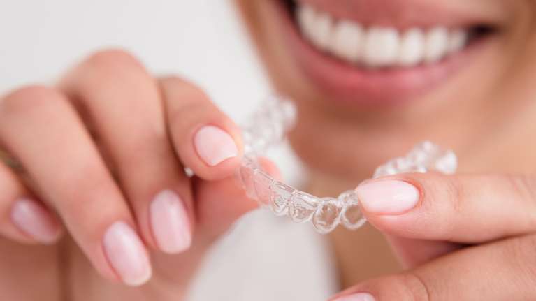 Woman's clean hands holding aligners in Phoenix
