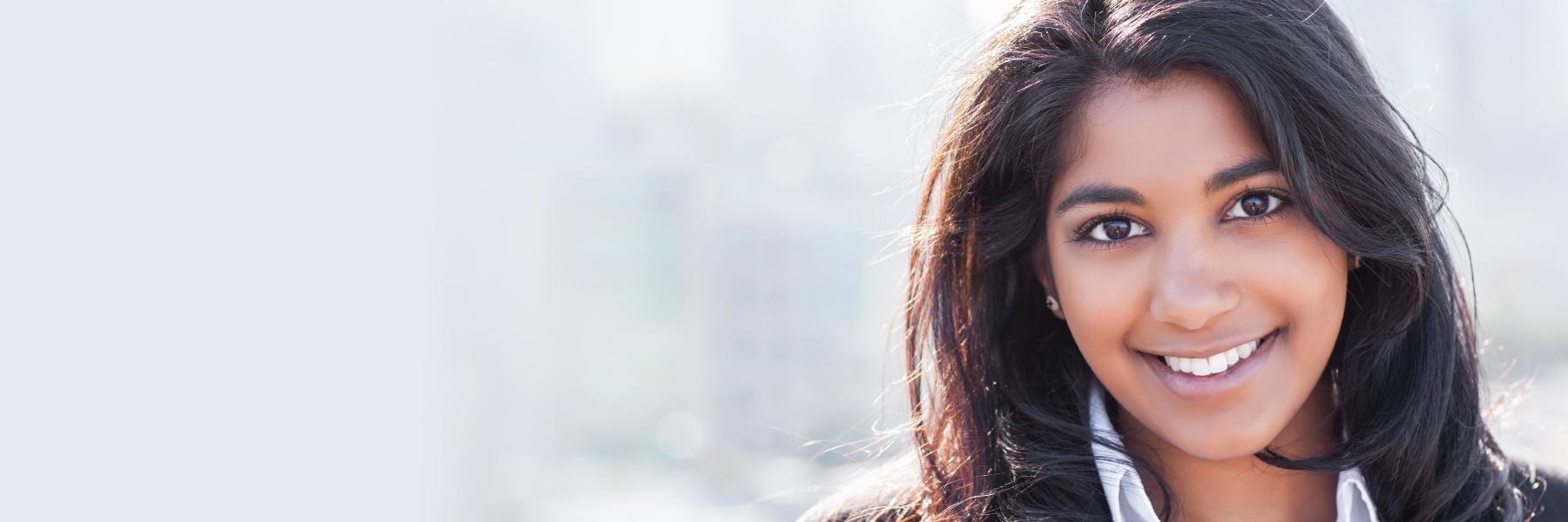 Woman with dental implant smiling outside of Dentist office